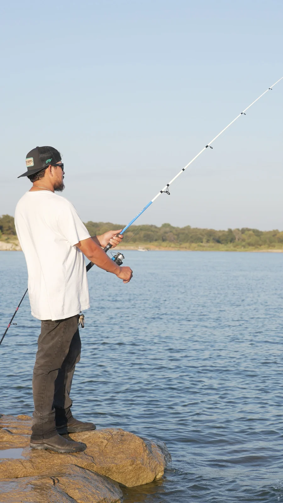 A person fishing beside a lake in Flower Mound